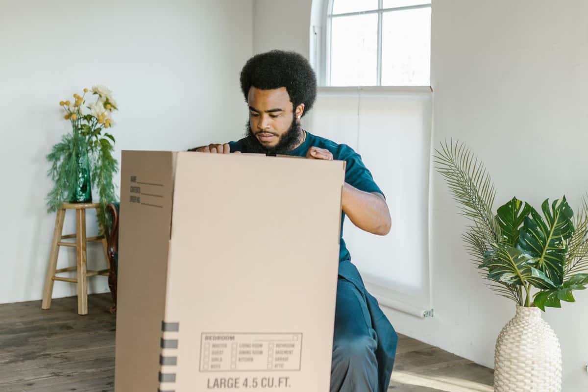 Two people assembling a wooden crib in a living room