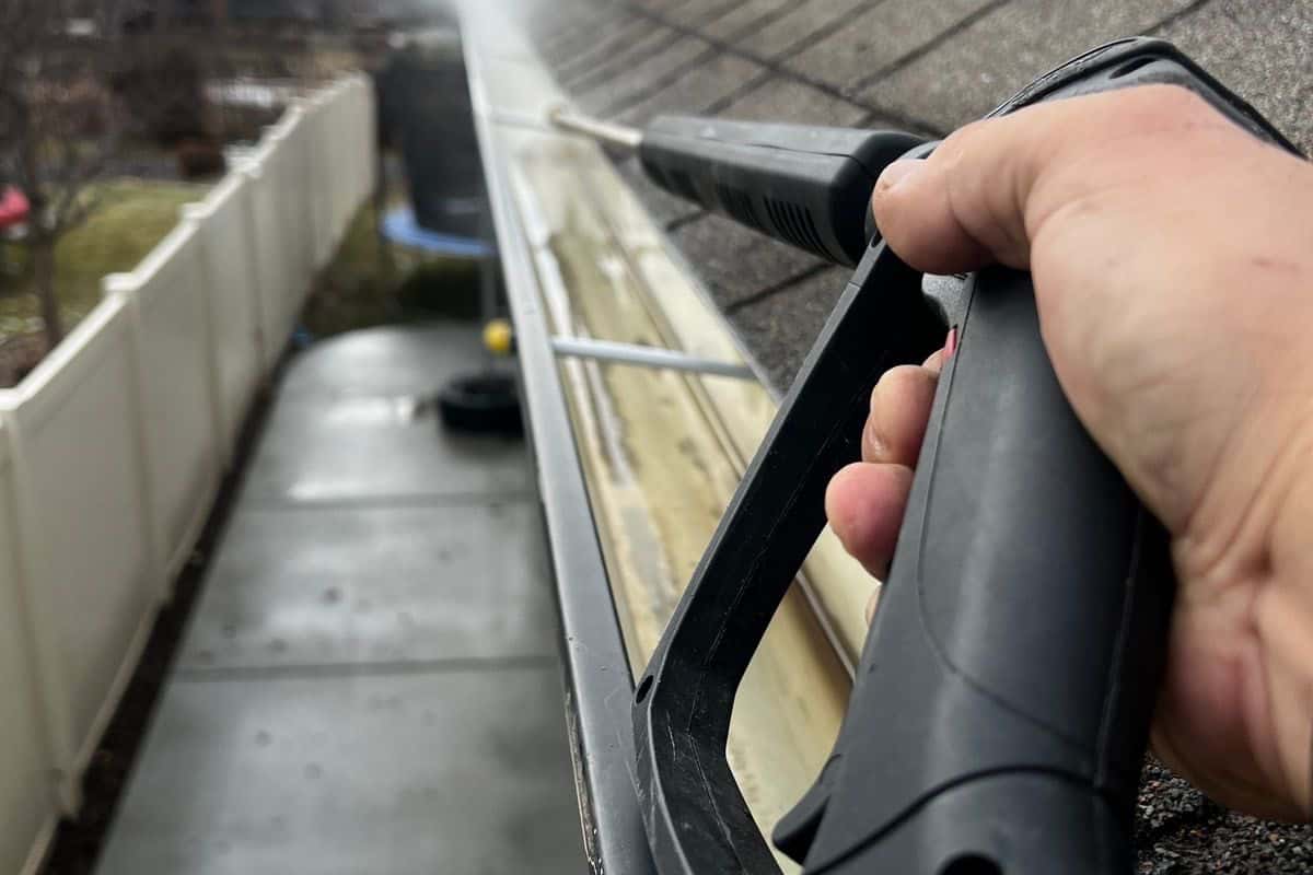 A gutter being cleared with a pressure washer