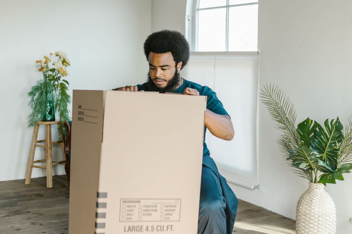 Two people assembling a wooden crib in a living room