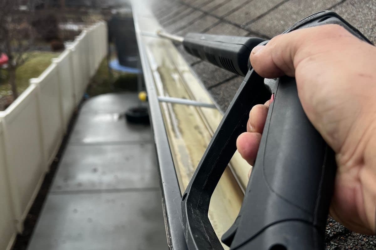 A gutter being cleared with a pressure washer
